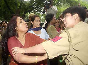 A policewoman tries to restrain an angry Mahila Congress activist