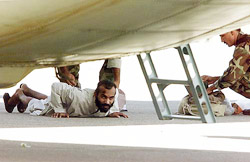 Pakistani soldiers search a Pakistani Taliban prisoner 