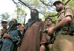Two masked suspected militants are paraded for the media