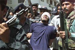 Security officials escort a gunman after a shootout in the southern port city of Karachi