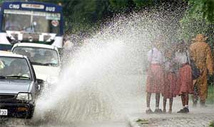 Vehicles splash a group of schoolchildren