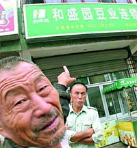 A Chinese man points to the Heshengyuan Soy Milk chain