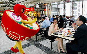 A man dressed as a bowl of noodles greets office workers