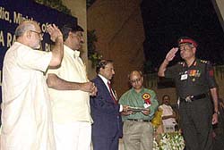 Union Labour Minister Sahib Singh Verma gestures as Station Workshop EME Jabalpur Col. R. S. Wankhede comes to receive the National Safety Awards