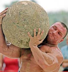 Jarek Dymek of Poland carries a 120-kg stone