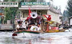 Supporters of the National Conference travel in a motorboat during an election rally in Srinagars Dal Lake
