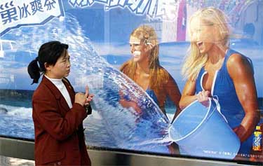 A Chinese woman walks past a poster