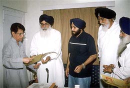 SAD President Parkash Singh Badal presents a memo on paddy procurement to Mr Ajit Singh