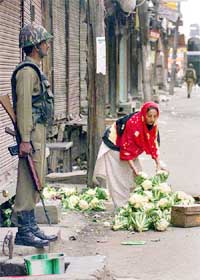 A Kashmiri woman collects her scattered vegetables