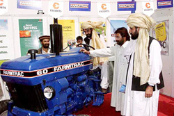 Afghan farmers inspect an Indian-made tractor