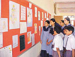 Students view paintings on display at Baba Isher Singh Senior Secondary School in Ludhiana on Friday.
