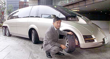 Professor Hiroshi Shimizu of Keio University poses next to the world's fastest electric vehicle