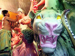 An artist paints a clay idol of Durga
