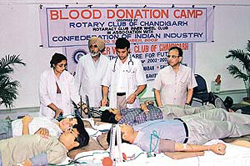 Volunteers donate blood at a camp organised at the CII in Chandigarh on Monday.