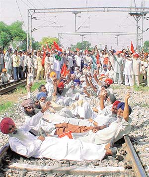 Farmers of various unions stage a sit-in on the rail track 