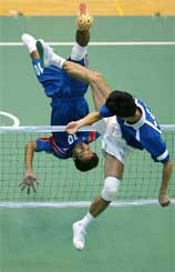 Poonsak Permsap of Thailand  somersaults to kick the ball past Yoo Dong-young of South Korea during their sepak takraw match