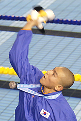 Japans Cho Sung-mo throws his Asian Games mascot to spectators after winning the silver medal in the mens 1,500m freestyle 