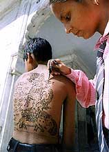 A student applies mehndi on the occasion of Wild Life Week
