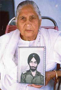Ms Surinder Kaur, mother of Capt Ravinder Singh, with the picture of her son