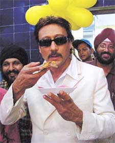 Bollywood star Jackie Shroff eating a pizza after inaugurating Smokin’ Joe’s pizza outlet