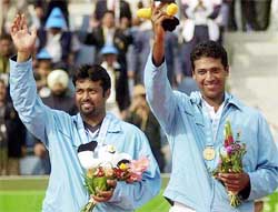 India's Leander Paes and his partner Mahesh Bhupathi wave during a medal ceremony for the men's doubles tennis competition