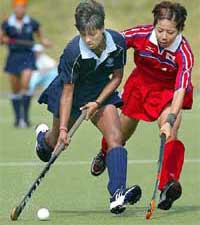Anjum Saba of India and Naoko Saito of Japan vie for the ball during the Asian Games womens hockey third place
