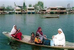 Kashmir women and their kids sail through the picturesque Dal Lake sitting in a Shikara on Sunday