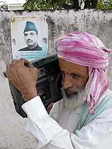 A passer-by listens the news of the government formation