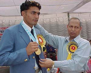 The Principal of DAV College, Bathinda, Mr J.P. Singal, honours Manpreet Singh Maana for winning the gold medal