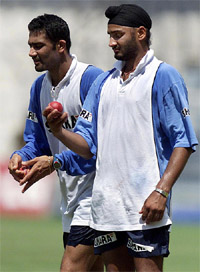 Harbhajan Singh looks at the ball as team-mate Anil Kumble runs in to bowl during a practice session in Chennai
