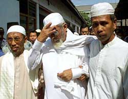 Indonesian militant Muslim cleric Abu Bakar Bashir, accused by neighbouring countries of leading a regional terror network, holds his forehead 