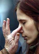 A young woman has a tear wiped from her face