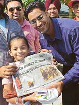 Harbhajan Mann presents a gift to a young reader of ‘The Tribune’, in Ludhiana on Sunday
