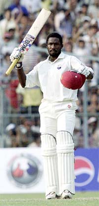 West Indies batsman Wavell Hinds shows his bat after making 100 runs during the second day's play of the third Test match 