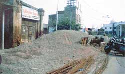 Huge heaps of bajri and construction material that have been dumped in front of houses and shops 
