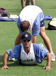 India's cricket team physiotherapist Andrew Leapus helps key batsman Virender Sehwag