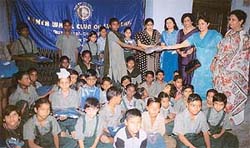 A student gets a sweater from members of the Inner Wheel Club at a function held in the Arya School for Boys
