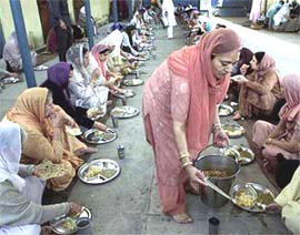 Sikh families from England enjoy a langar at Darbar Sahib in Lahore