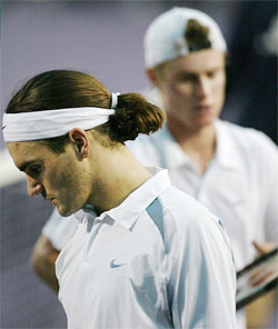 Roger Federer of Switzerland walks past Lleyton Hewitt