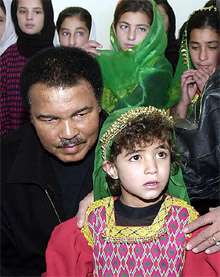 Boxing legend Muhammad Ali puts his hand on the shoulder of an Afghan child 