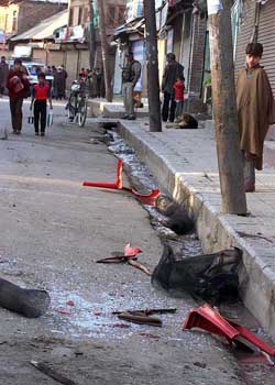 People walk near the site of a landmine explosion