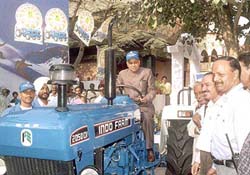 Himachal Pradesh Chief Minister Prem Kumar Dhumal riding on a tractor