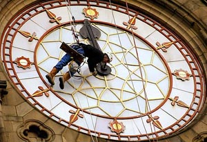 A clock repairer from Cumbria Clock Company works on one of the faces of the Manchester City hall clock