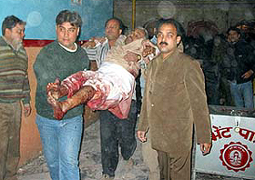 Volunteers carry the body of a pilgrim out of a temple in Jammu