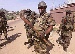 Soldiers look at a weapon used during the riots in Kaduna, Nigeria