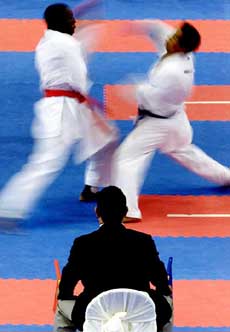 A judge watches Honduras' Carlos Fajarto and Salvadoran Jaime Avalos