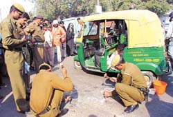 Policemen examining the spot where a Delhi Police constable overpowered a gangster after an encounter on the busy Mathura Road in the Capital on Wednesday.