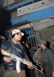 An Afghan policeman guards the entrance of a building from where a blast occured on Tuesday in the outskirts of Kabul.