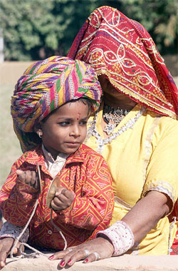 A boy dressed in Rajastani attire plays 'chaina,'