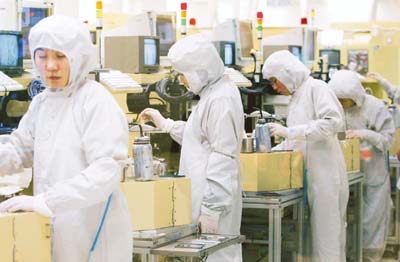 Employees work on a production line manufacturing hard disk drives